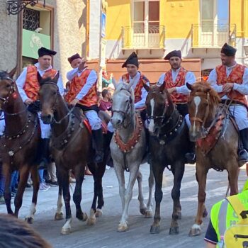 un gruppo di cavalieri indossa vestiti tradizionali sardi e sfila per la vie di Stampace a Cagliari